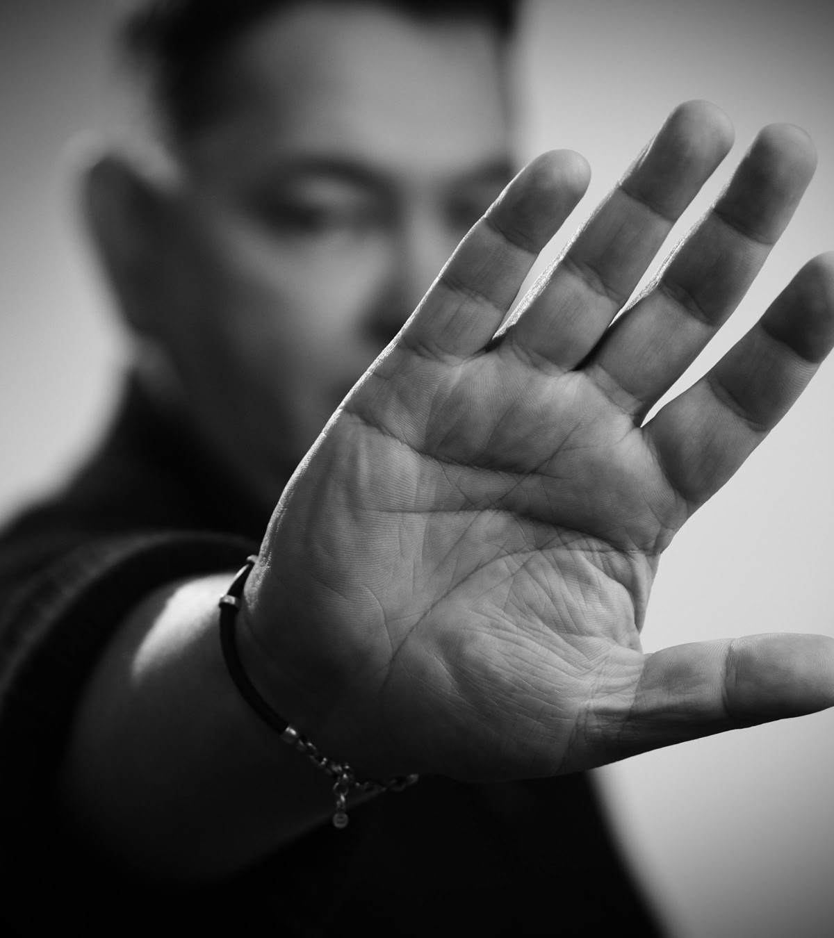 A man's hand extended showing the one palm, lnes and fingers in greyscale colour